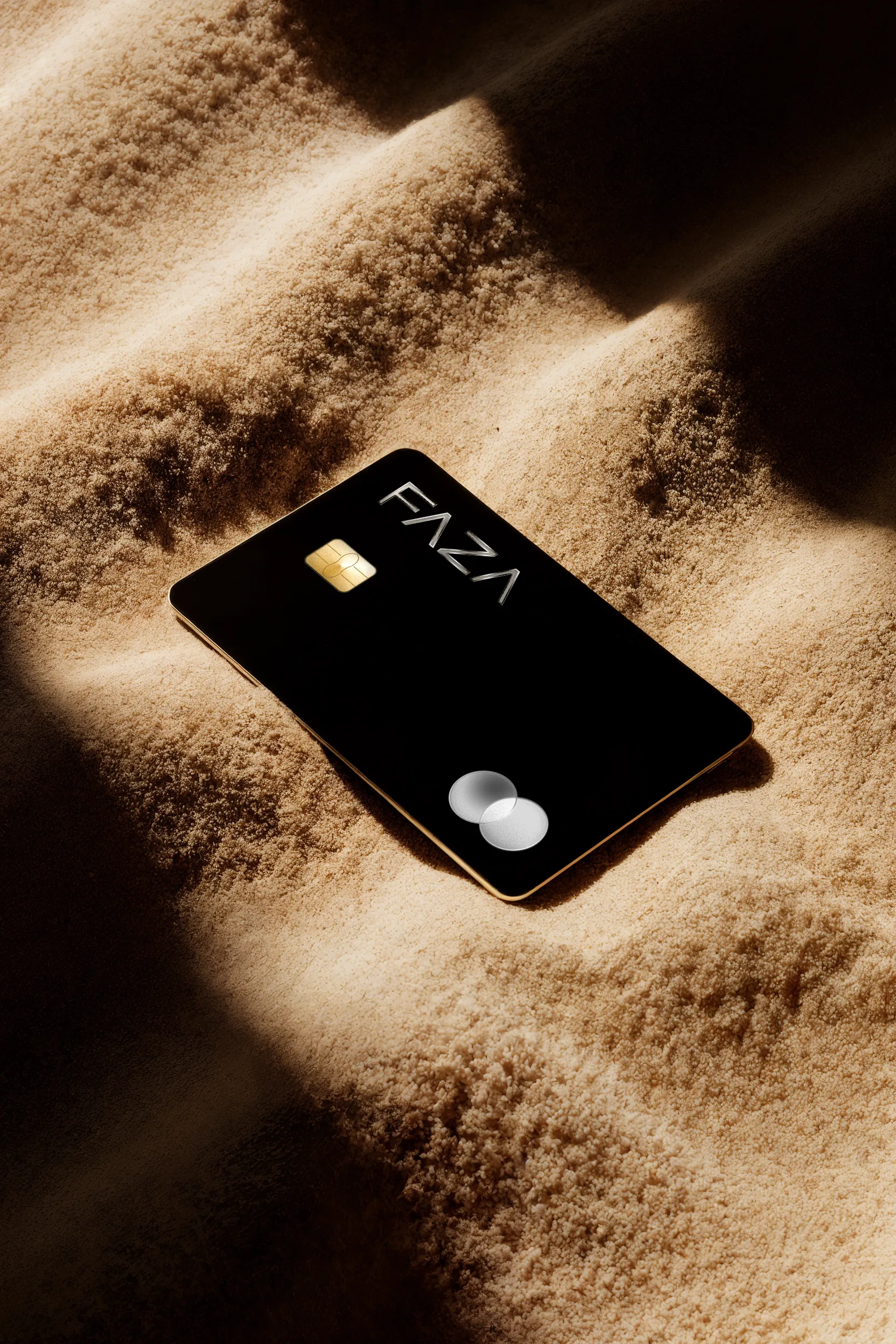 FAZA black card lying on warm sand with soft side light
